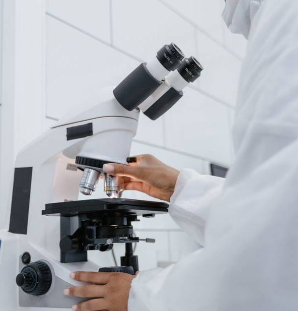 Scientist using microscope for research in a modern laboratory setting.