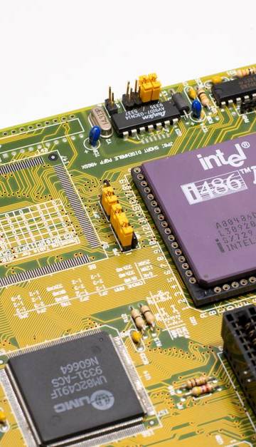 Close-up of a vintage Intel 486 CPU motherboard with PCI slots, highlighting retro technology components.