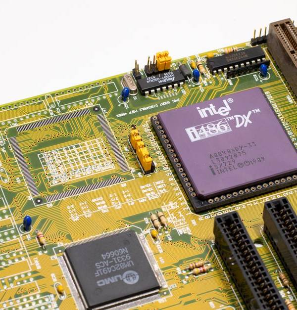 Close-up of a vintage Intel 486 CPU motherboard with PCI slots, highlighting retro technology components.
