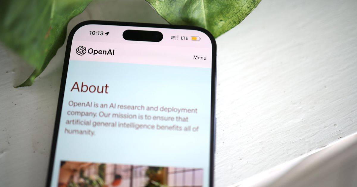 Close-up shot of a smartphone screen showing the OpenAI website with greenery in the background.