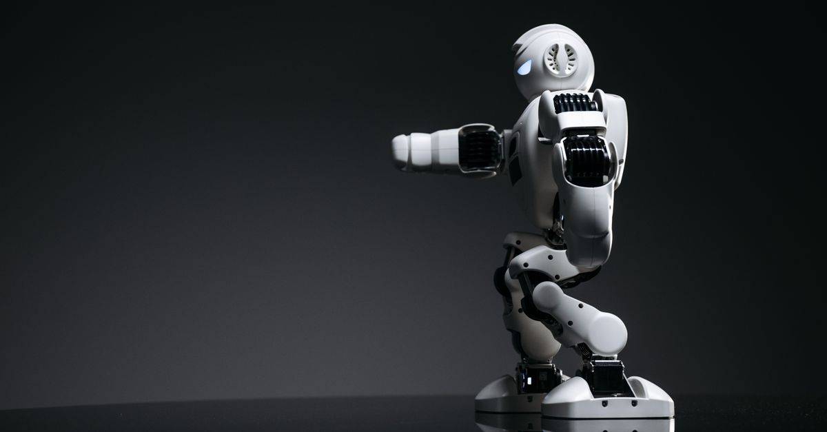 A white robot showcasing modern design on a sleek dark surface.