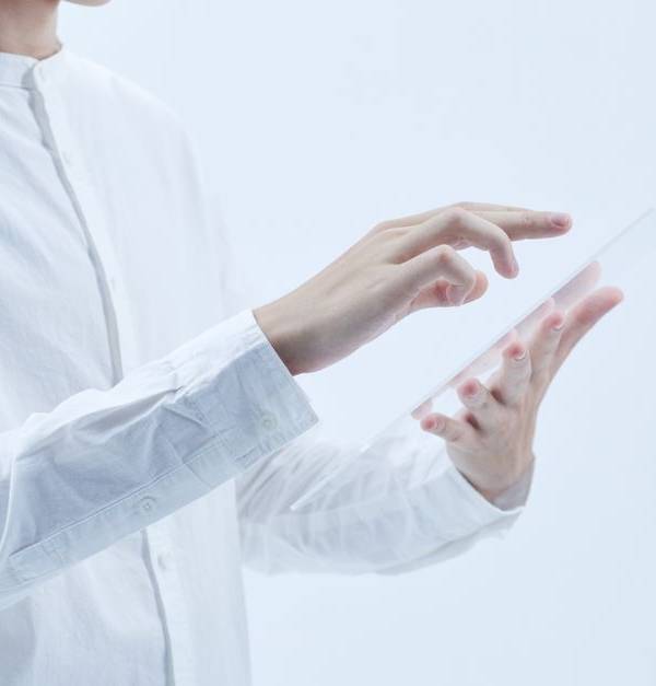 Person interacting with a transparent digital tablet, symbolizing technology and futurism.