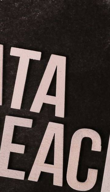 A conceptual image highlighting the issue of data breaches, featuring bold text on a textured background.