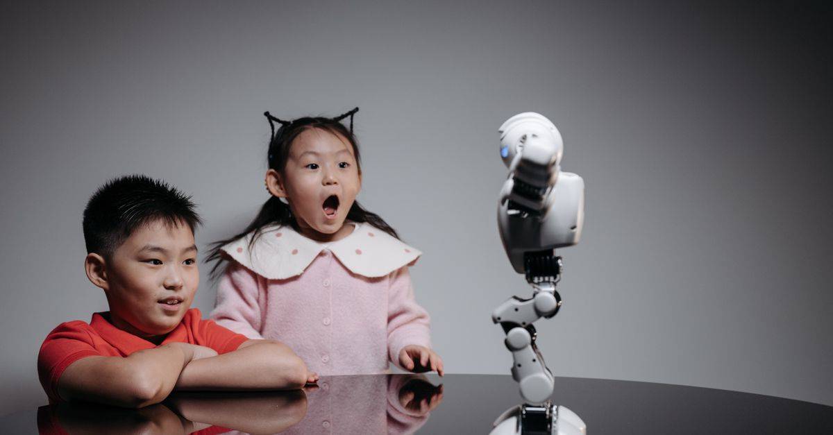 Two children fascinated by a toy robot, showcasing excitement and curiosity indoors.