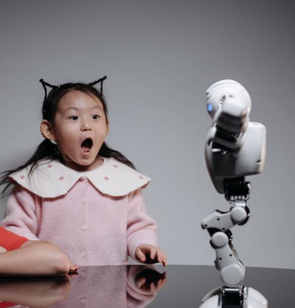 Two children fascinated by a toy robot, showcasing excitement and curiosity indoors.